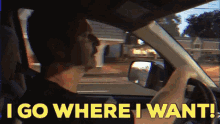 a man driving a car with the words " i go where i want " on the screen