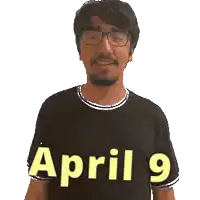 a man wearing glasses and a black shirt with the words april 9 on it