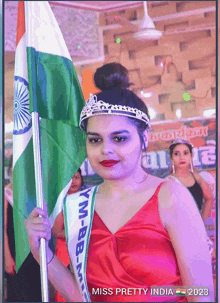 miss pretty india is holding a flag and wearing a sash