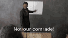 a man giving a presentation with the words " not our comrade " on the bottom