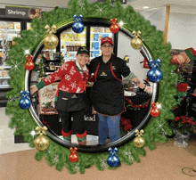 two women standing in front of a wreath with a sign that says shrimp on it