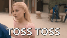 a woman in a pink dress is standing next to a man in a blue shirt and says `` toss toss '' .