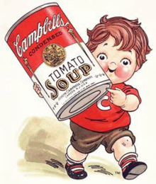 a child is holding a can of campbell 's tomato soup .