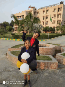 a redmi note 5 pro mi dual camera shows two children holding balloons