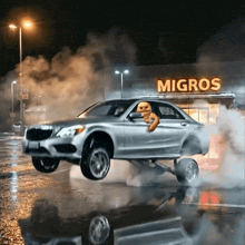 a car is doing a wheelie in front of a migros
