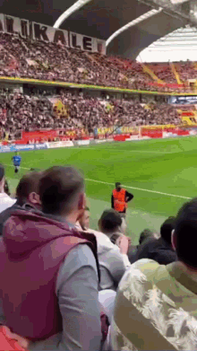 a crowd of people are watching a soccer game in a stadium with a sign that says lokalet on it