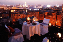 a table and chairs on a balcony overlooking a city