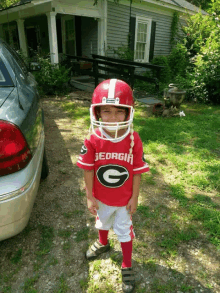 a young boy in a georgia jersey and helmet