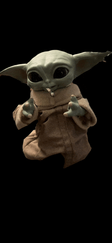 a baby yoda with a cigarette in its mouth