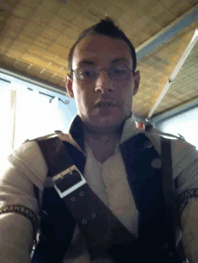 a man wearing glasses and a vest with a buckle