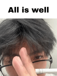 a man wearing glasses is covering his face with his hand while holding a marker .