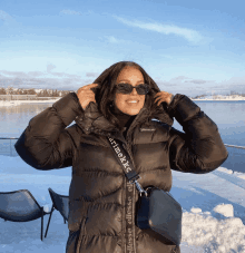 a woman wearing a black jacket with a strap that says marimekko on it