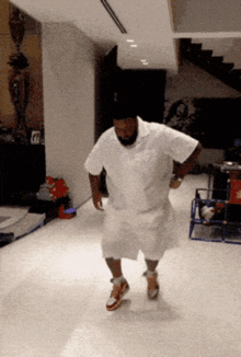 a man in a white shirt and shorts is dancing on the floor