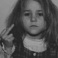 a young girl is giving the middle finger .