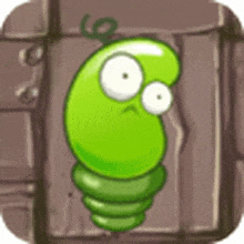 a green cartoon character with big eyes is standing next to a brick wall .