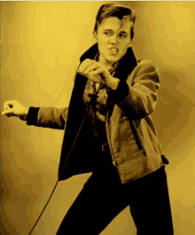 a young man singing into a microphone with a yellow background