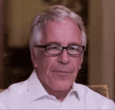 an older man wearing glasses and a white shirt