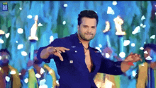 a man in a blue shirt is dancing in front of a blue background with the letters bf on it