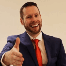 a man in a suit and tie is giving a thumbs up sign .