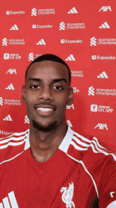 a man wearing a red adidas shirt with a flaming face