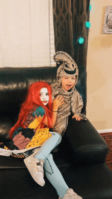 a little girl in a sally costume sits next to a little boy in a sally costume