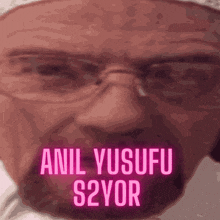 a close up of a man 's face with the words anil yusufu s2yor written in pink