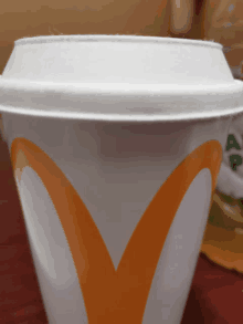 a close up of a mcdonald 's cup with an orange m on it