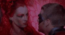 a man and a woman are looking at each other with red hair