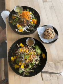 two salads and a muffin on a table with a napkin