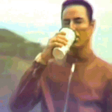 a man in a brown shirt is drinking from a plastic cup