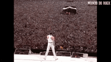 a man is standing on a stage in front of a crowd with the words mundo do rock above him