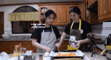 two women are preparing food in a kitchen and one of them is wearing an apron with a bear on it