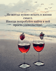 two wine glasses on a beach with a strawberry in one of them