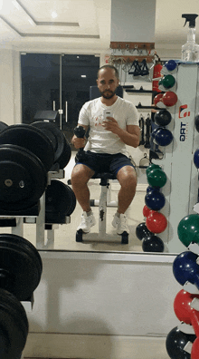 a man taking a picture of himself in a gym with a sign that says ' oat ' on it