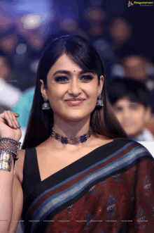 a woman wearing a choker and bracelets is smiling for the camera