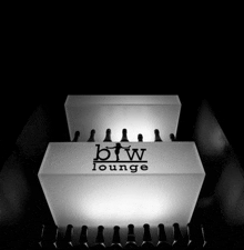 a white box with bw lounge written on it sits in a dark room