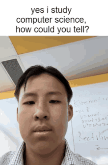 a young man stands in front of a whiteboard that says " yes i study computer science, how could you tell "