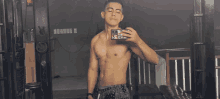 a shirtless man taking a picture of himself in a mirror