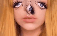 a close up of a woman 's face with a cartoon eye drawn on it .