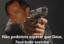 a man is pointing a gun at the camera with the words " não podemos esperar que deus faça tudo sozinho " below him