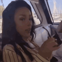 a woman is sitting in the driver 's seat of a boat holding a pair of sunglasses .