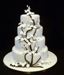 a white cake with white flowers on a black background