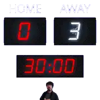 a scoreboard that says home and away with a man standing behind it