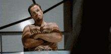 a man with his arms crossed has a tattoo on his chest