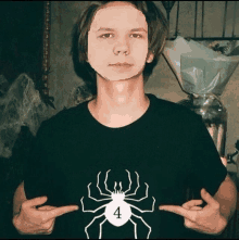 a man wearing a black shirt with a white spider and the number 4