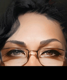 a close up of a woman 's face with glasses and a black hair