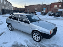 a silver car parked in a snowy parking lot