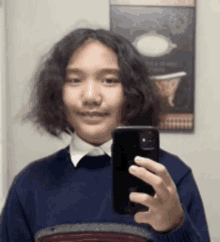 a young man is taking a selfie with a cell phone