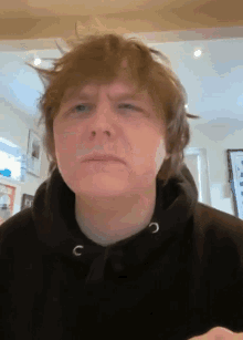 a man wearing a black hoodie with the letter c on the front of it