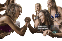 a group of young girls are arm wrestling and one of them is wearing a polka dot bikini